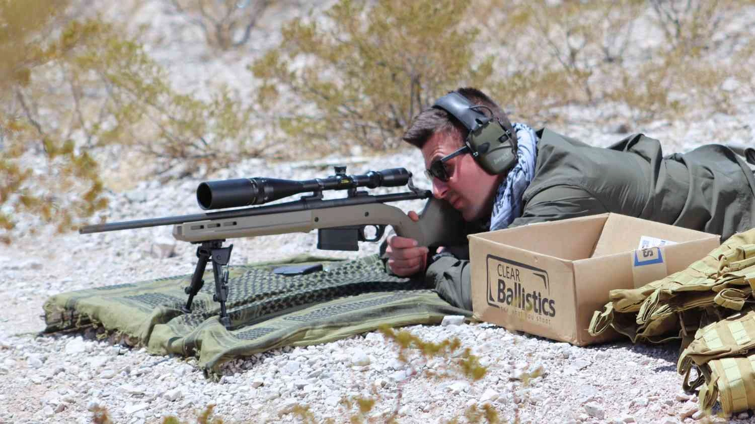 Shooter aiming rifle with Clear Ballistics gel test setup